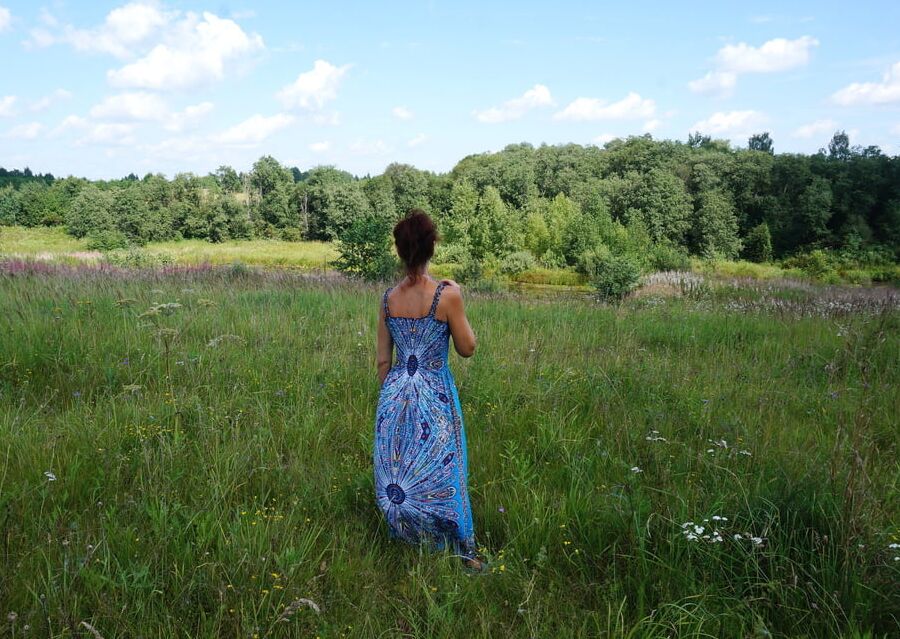 In blue dress in field