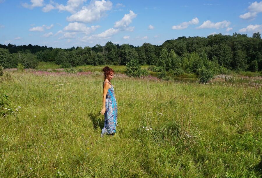 In blue dress in field