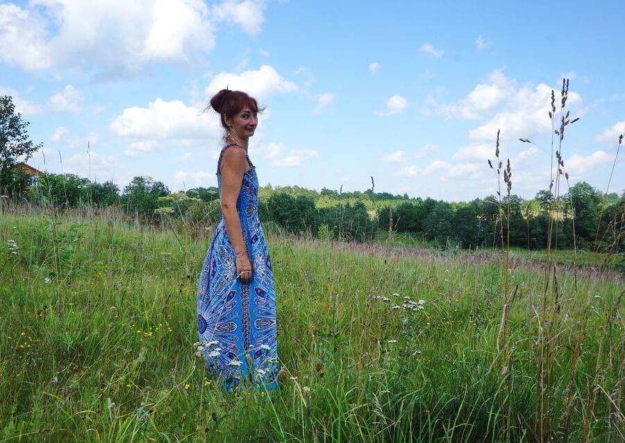 In blue dress in field