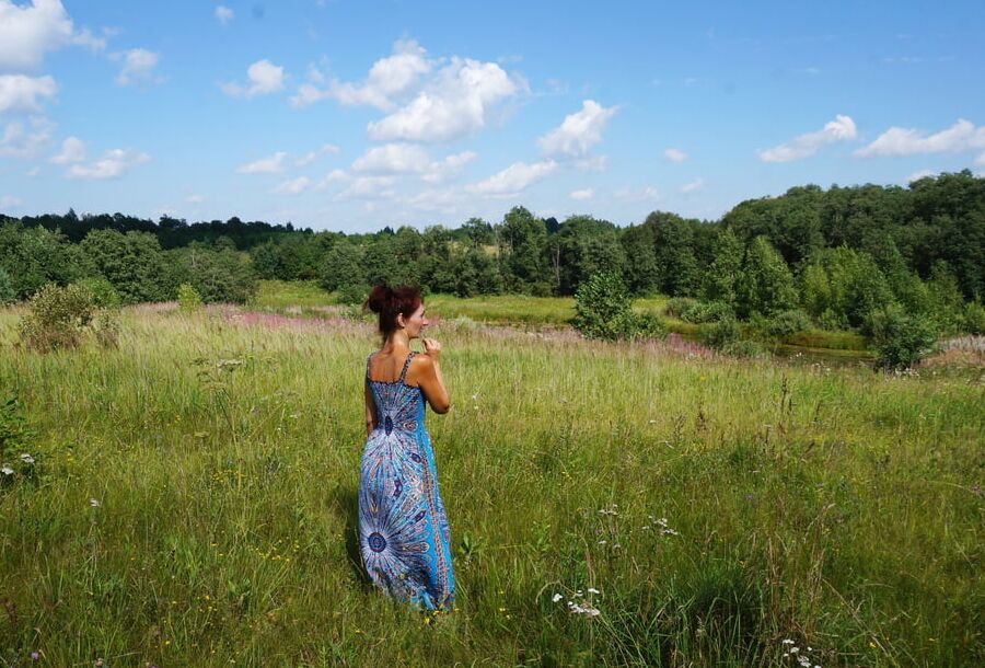 In blue dress in field