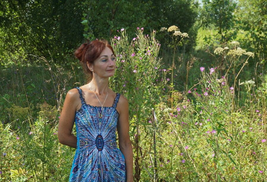In blue dress in field