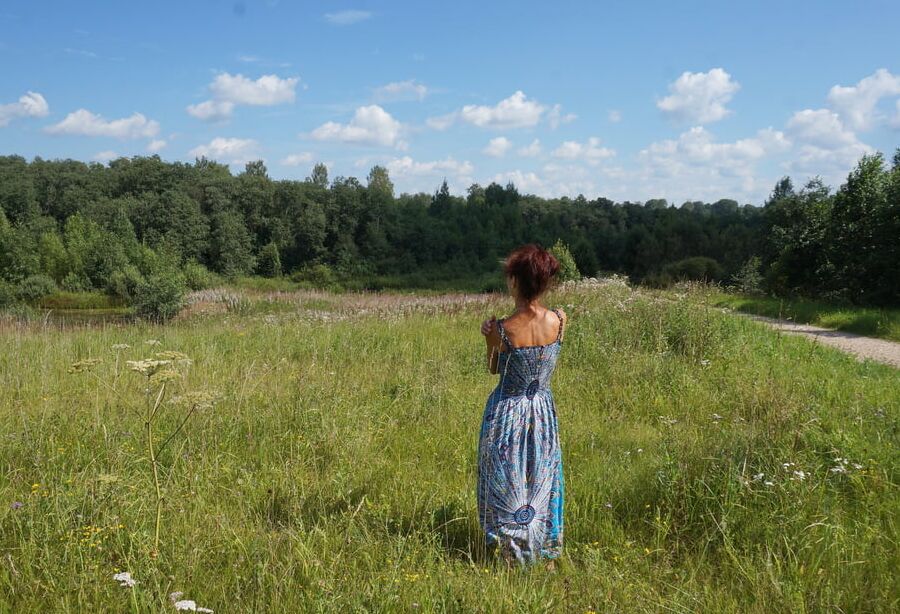 In blue dress in field