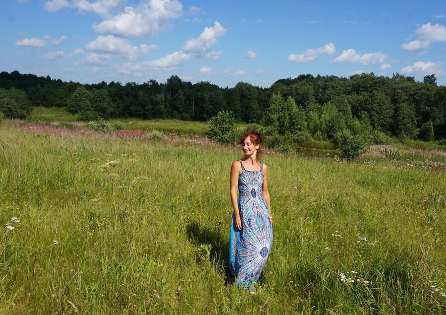 In blue dress in field