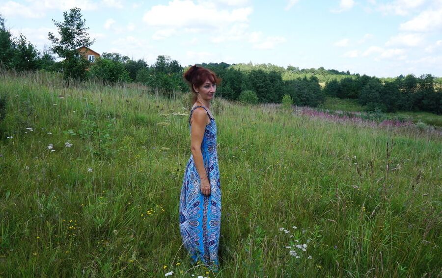 In blue dress in field