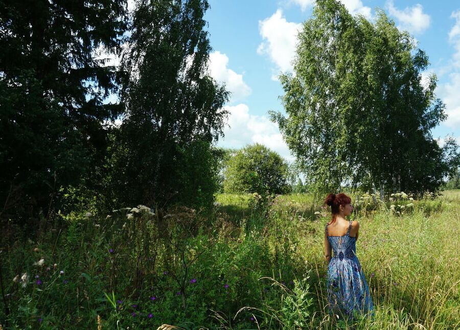 In blue dress in field