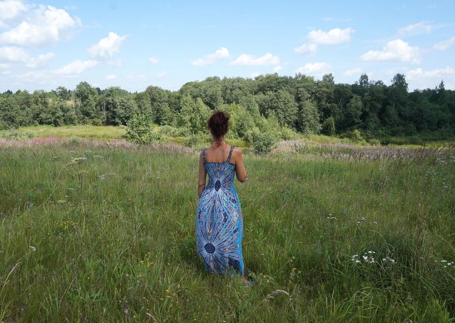 In blue dress in field