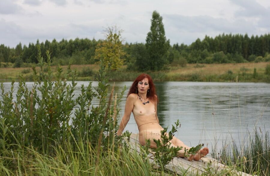 Naked on the planked footstay near the pond