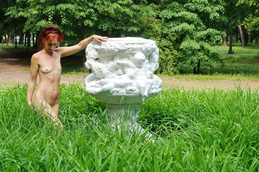 Naked in the grass by the vase