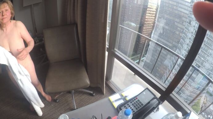 Mature masturbating GILF plays peek-a-boo with the city