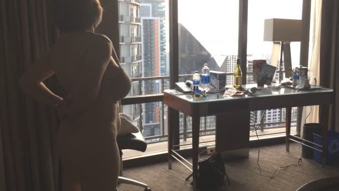 Mature masturbating GILF plays peek-a-boo with the city