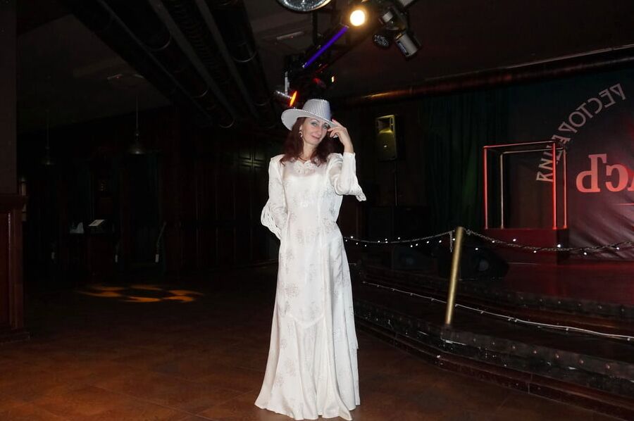 In Wedding Dress and White Hat on stage