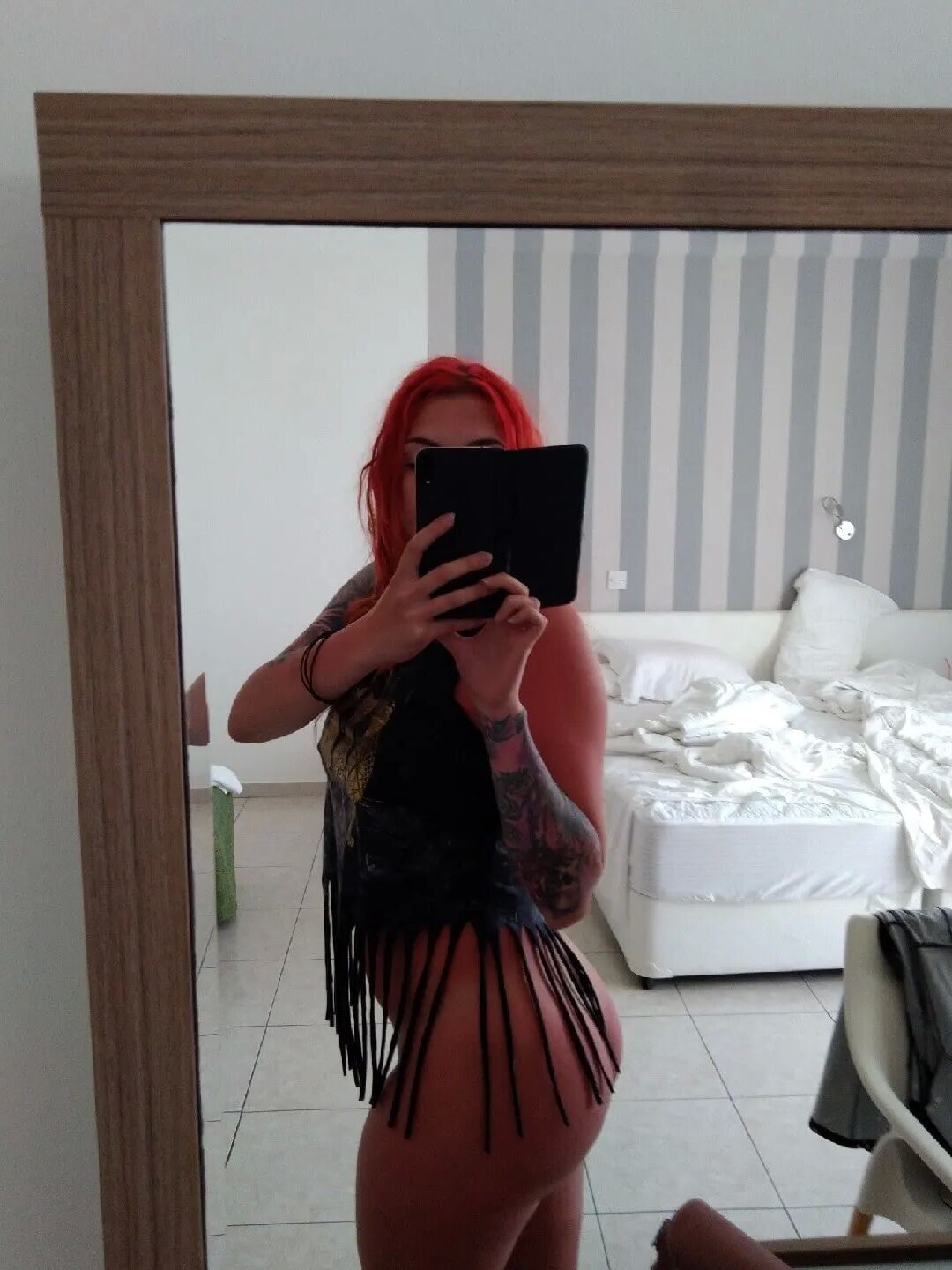 Tattooed babe with big tits sharing her figure