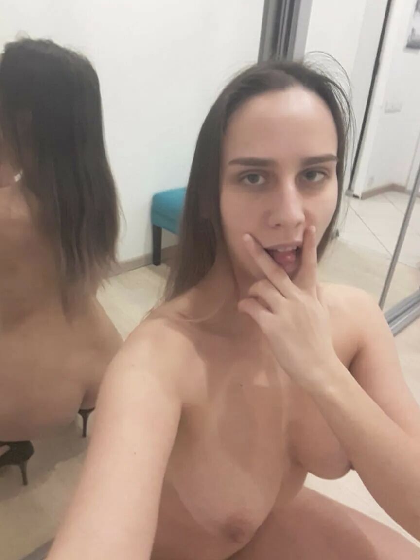 Foxy brunette shows us her tongue while posing