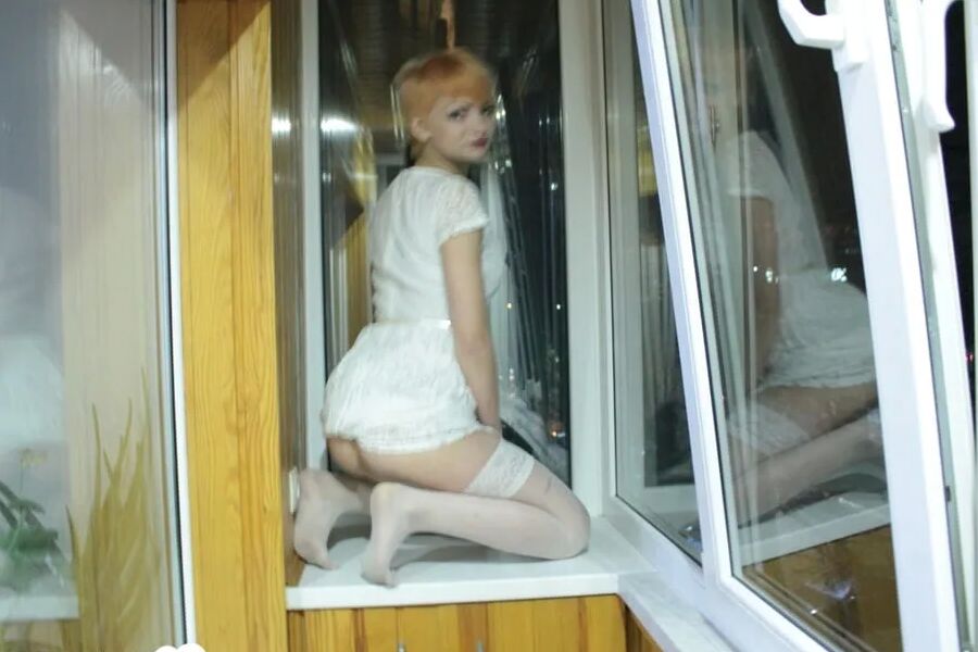 Hottie sits by the window in an outfit