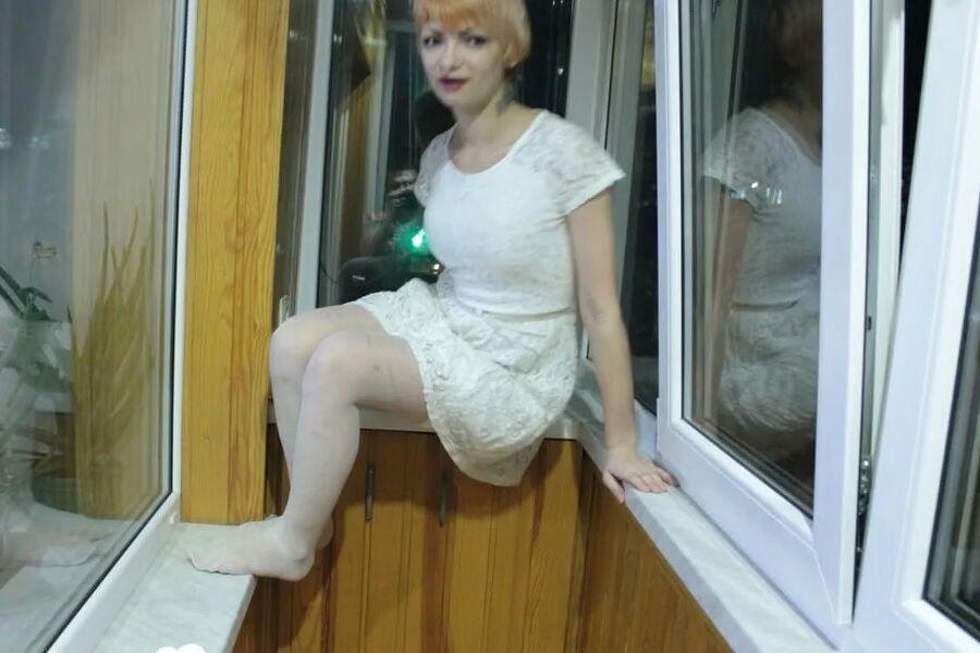 Hottie sits by the window in an outfit