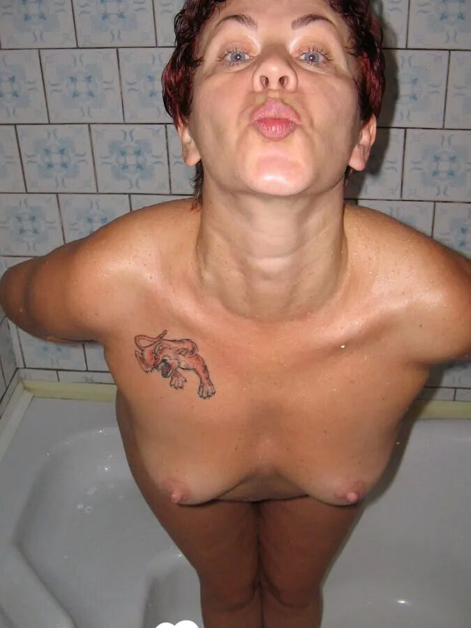 Redhead MILF pisses and takes a shower