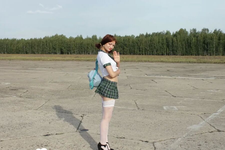 Incredible mom in a schoolgirl outfit posing outdoors