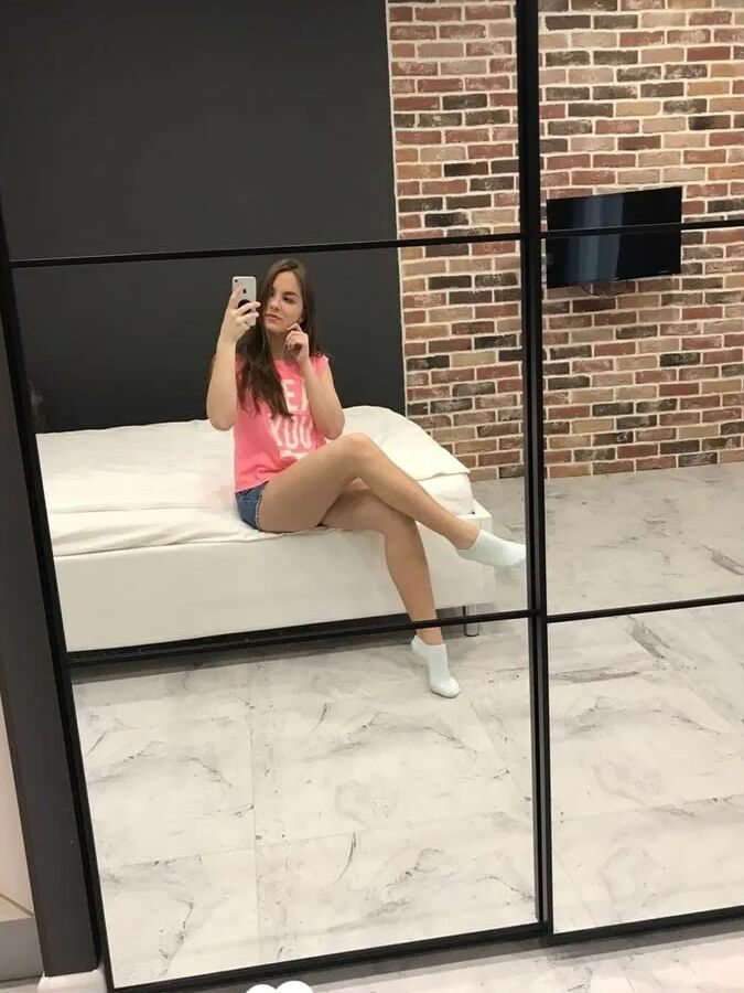 Horny teen plays with her phone while flashing