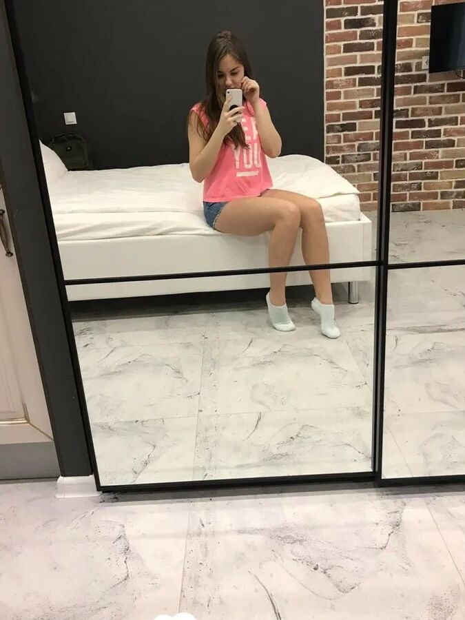Horny teen plays with her phone while flashing