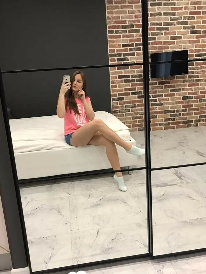 Horny teen plays with her phone while flashing