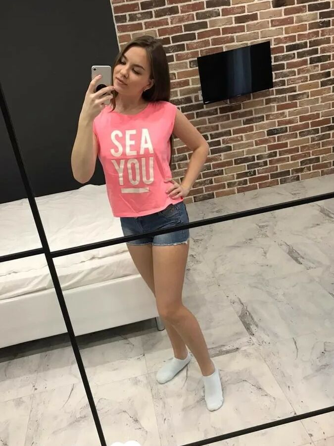 Horny teen plays with her phone while flashing
