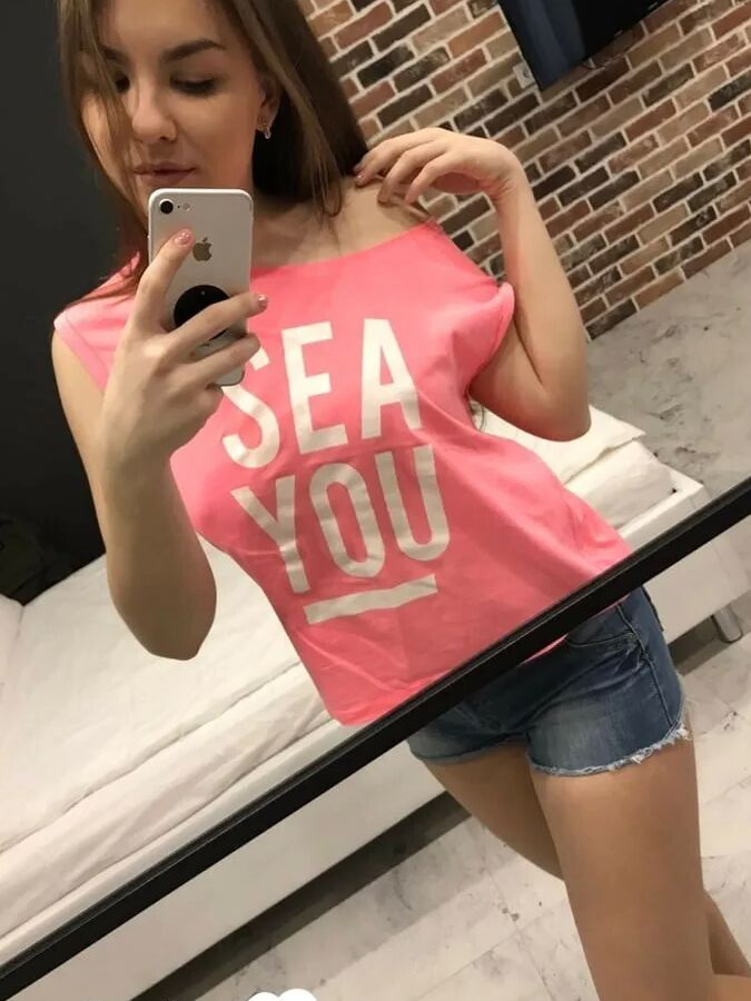 Horny teen plays with her phone while flashing