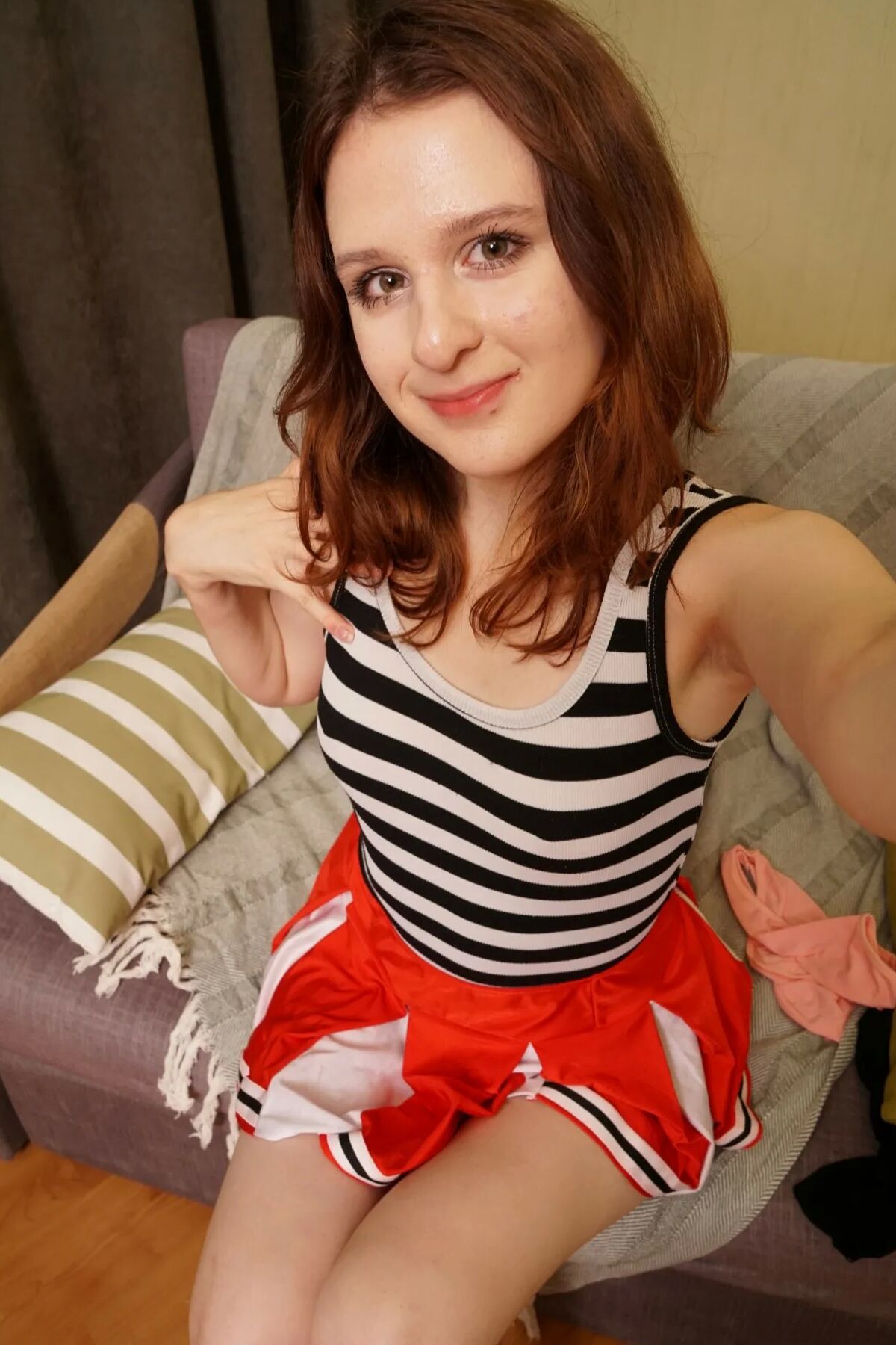 Redhead cutie shows off outfits and gets nude