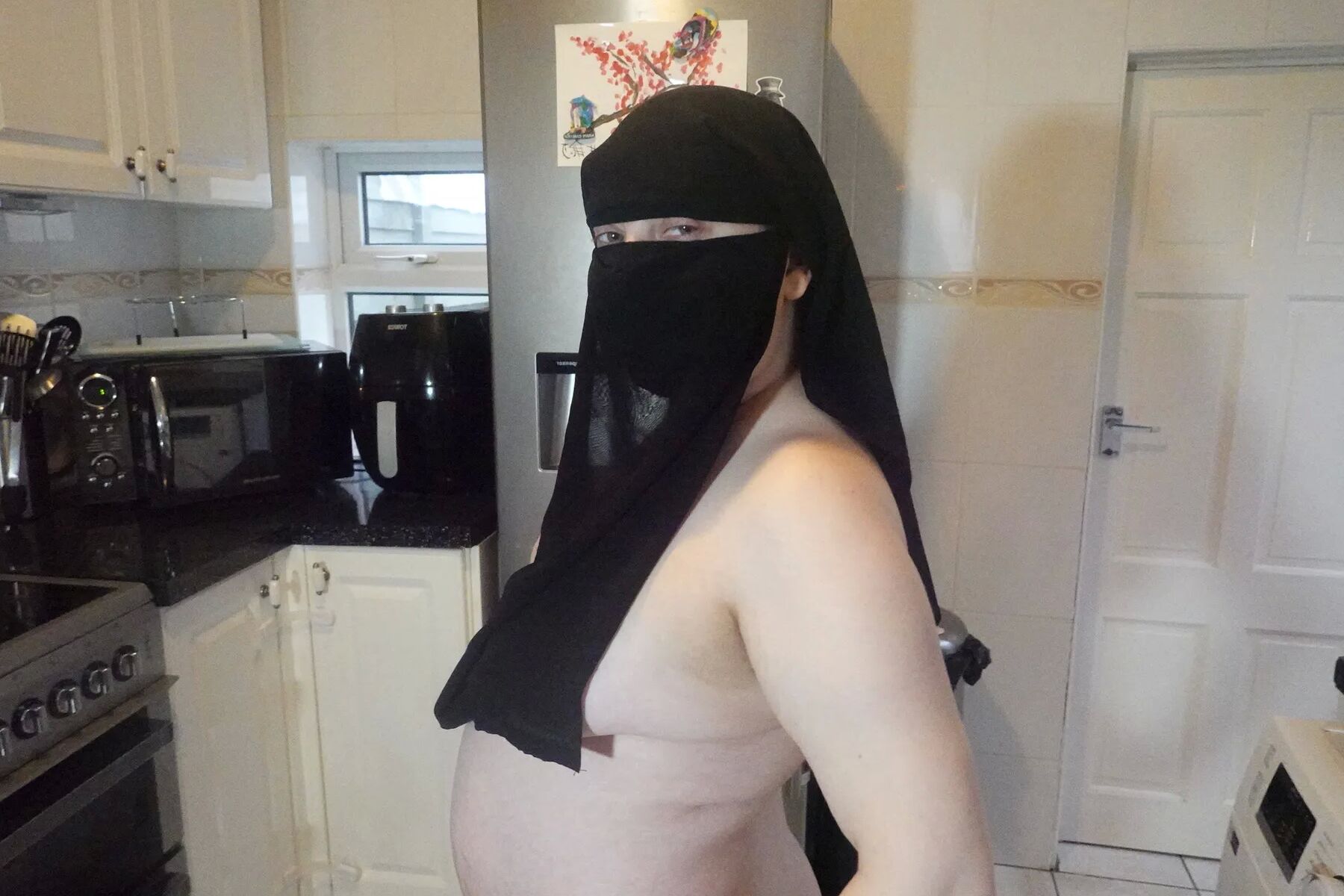 Posing fully nude in Niqab
