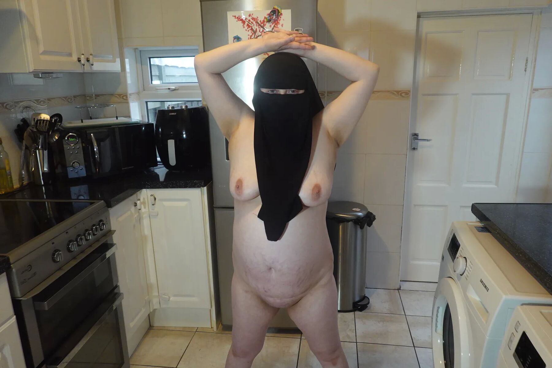Posing fully nude in Niqab