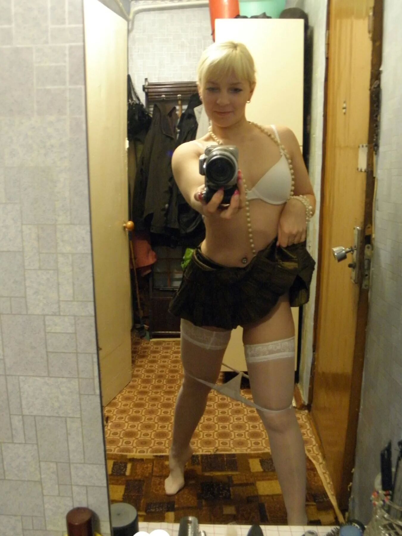 Aroused blonde in stockings taking naughty selfies