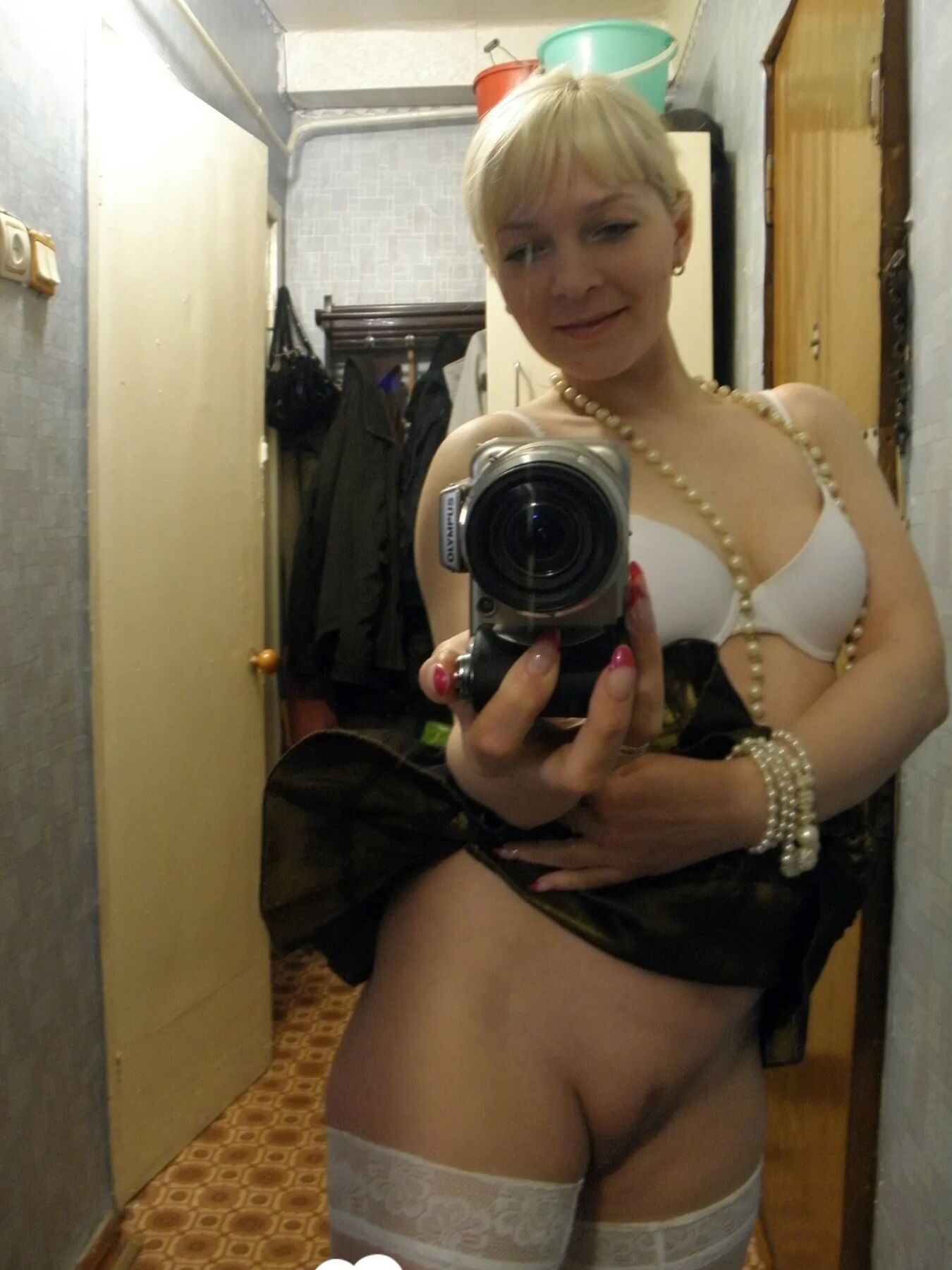Aroused blonde in stockings taking naughty selfies