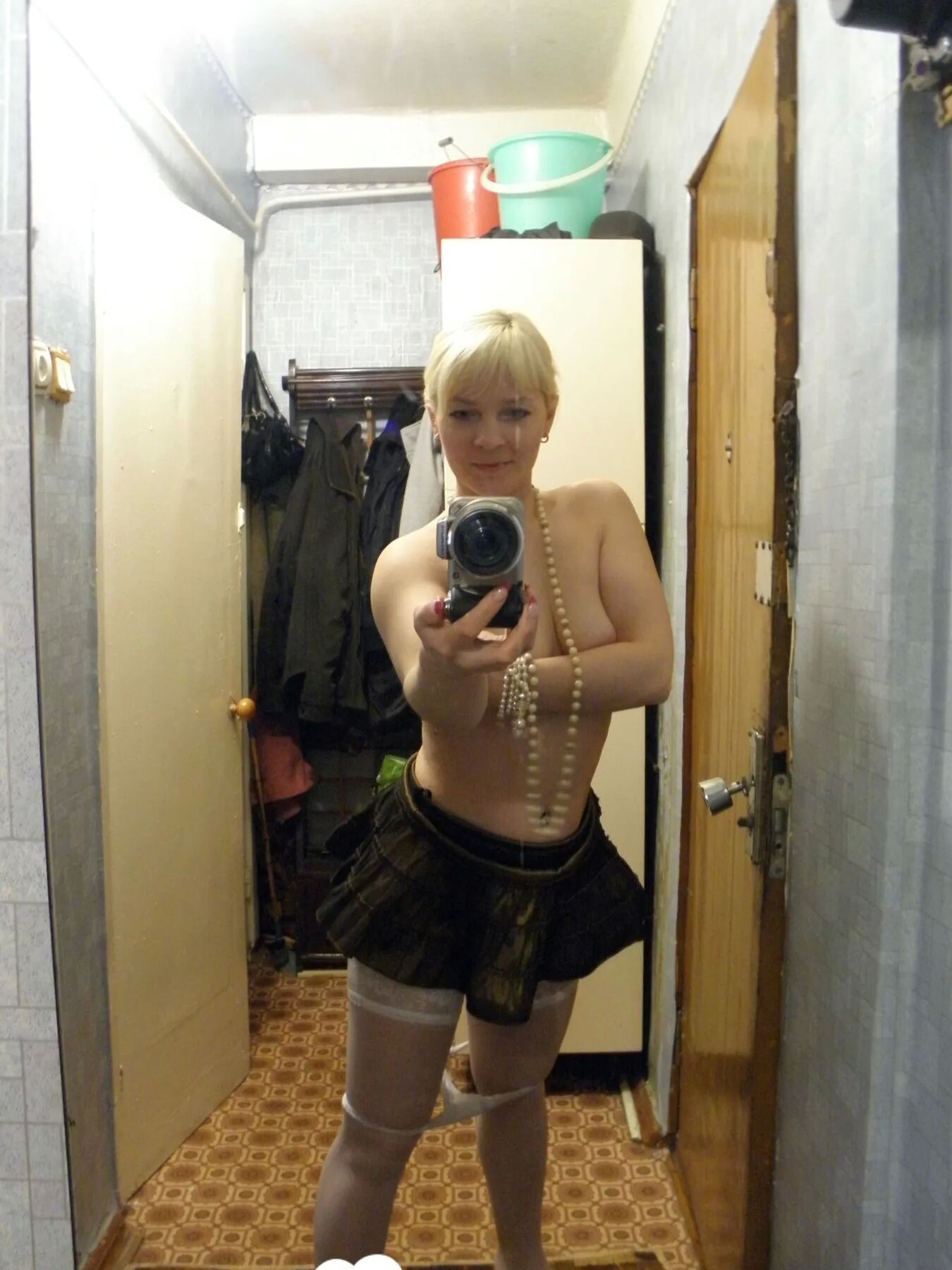 Aroused blonde in stockings taking naughty selfies