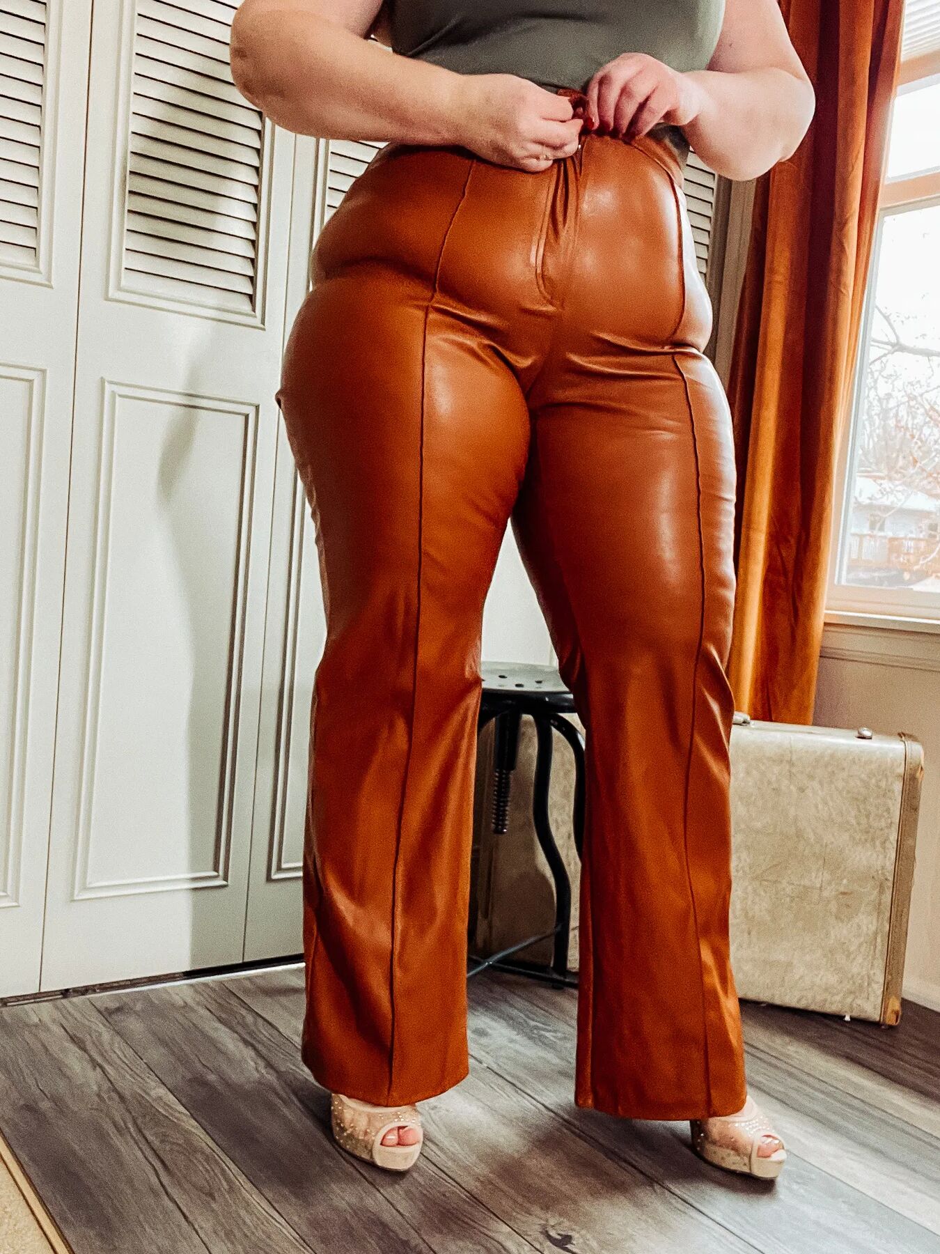 BBW in tight leather pants leans over and shows off her ass