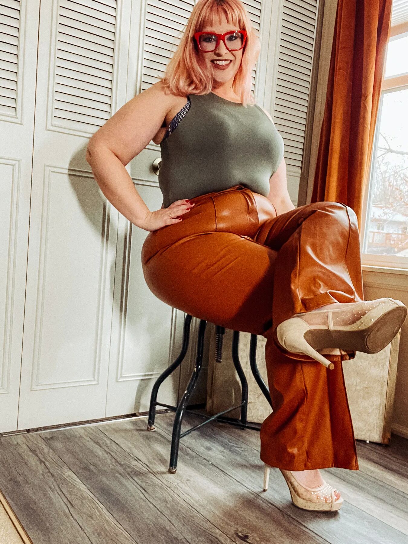 BBW in tight leather pants leans over and shows off her ass