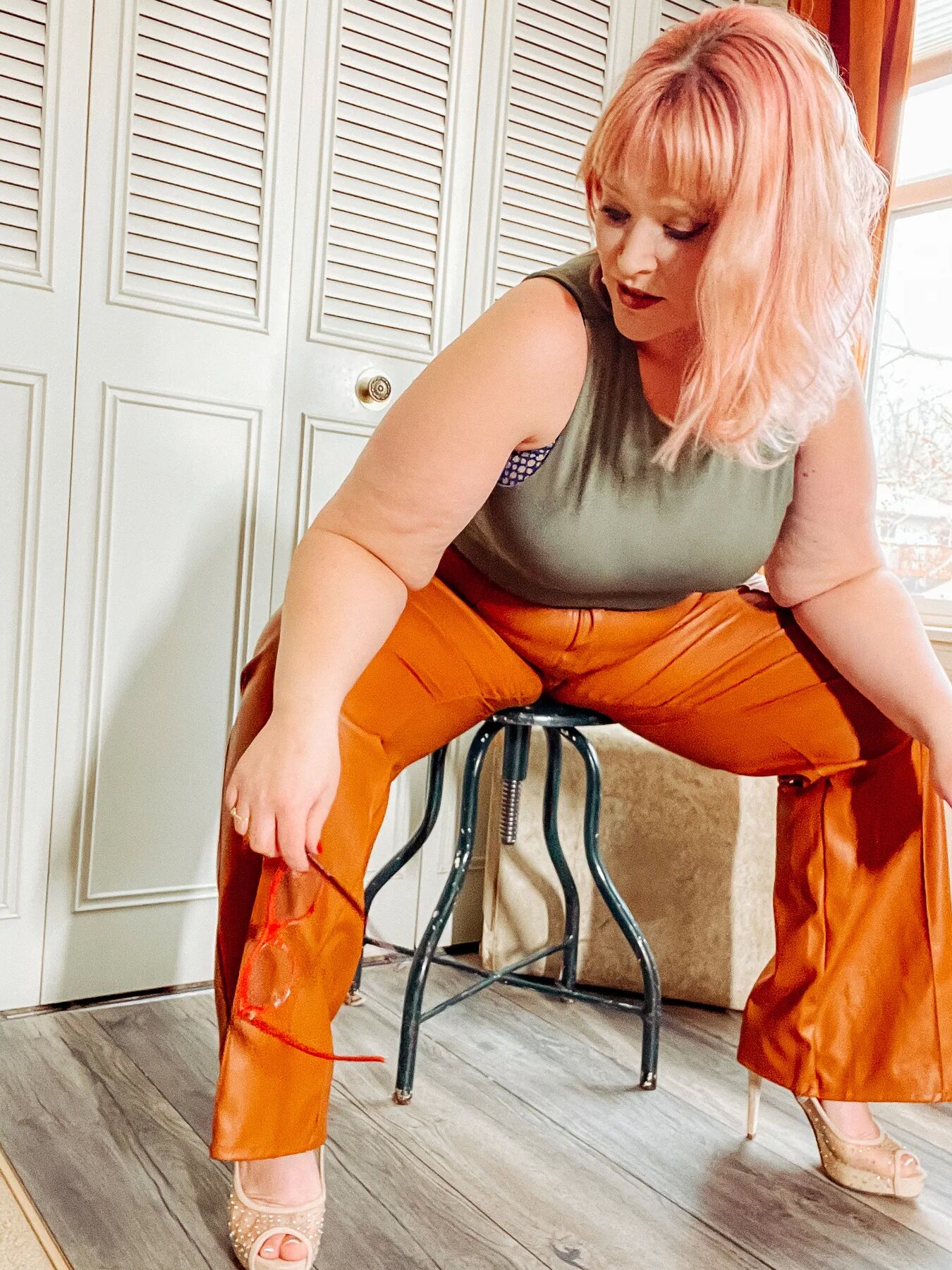 BBW in tight leather pants leans over and shows off her ass
