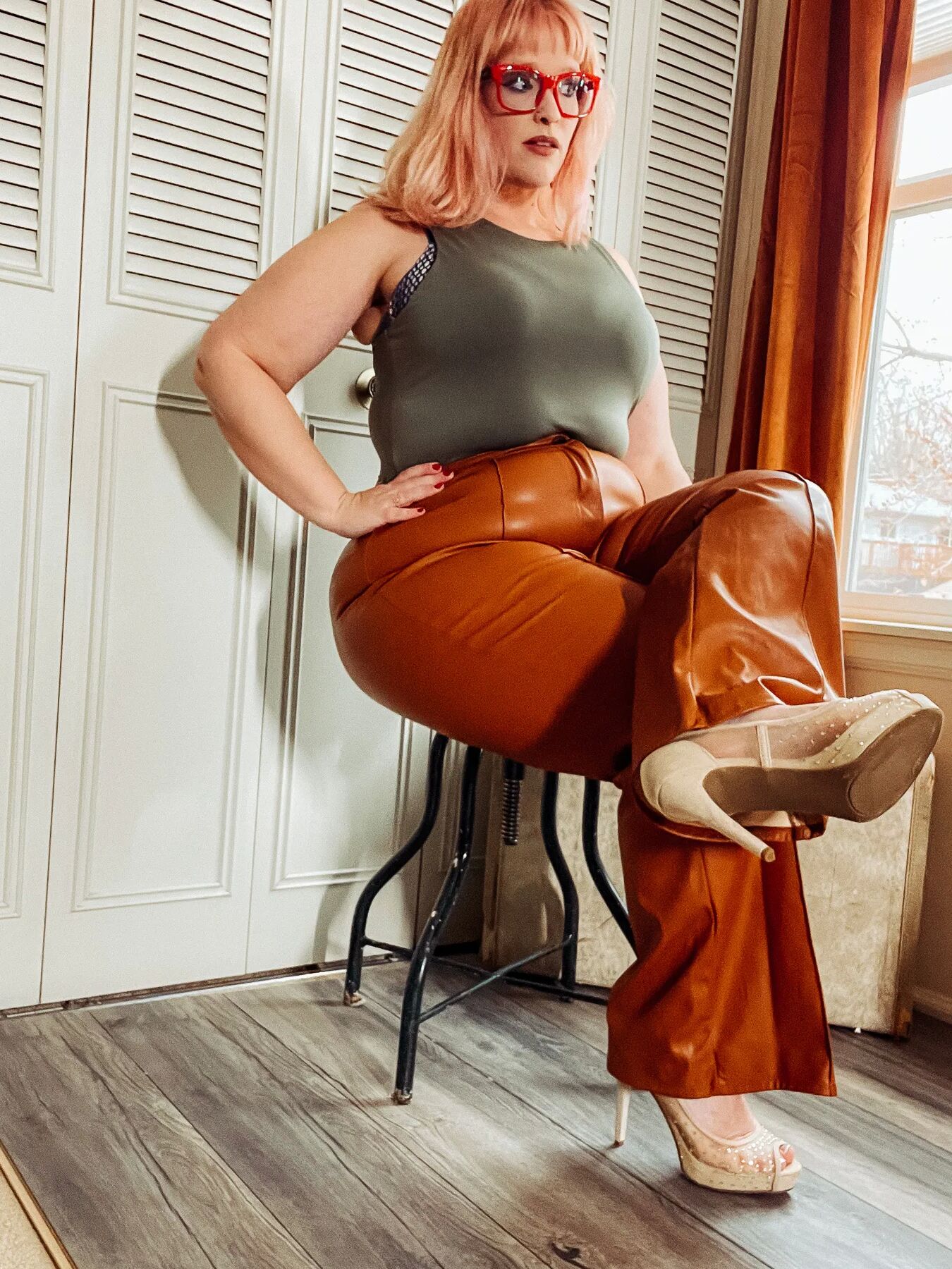 BBW in tight leather pants leans over and shows off her ass