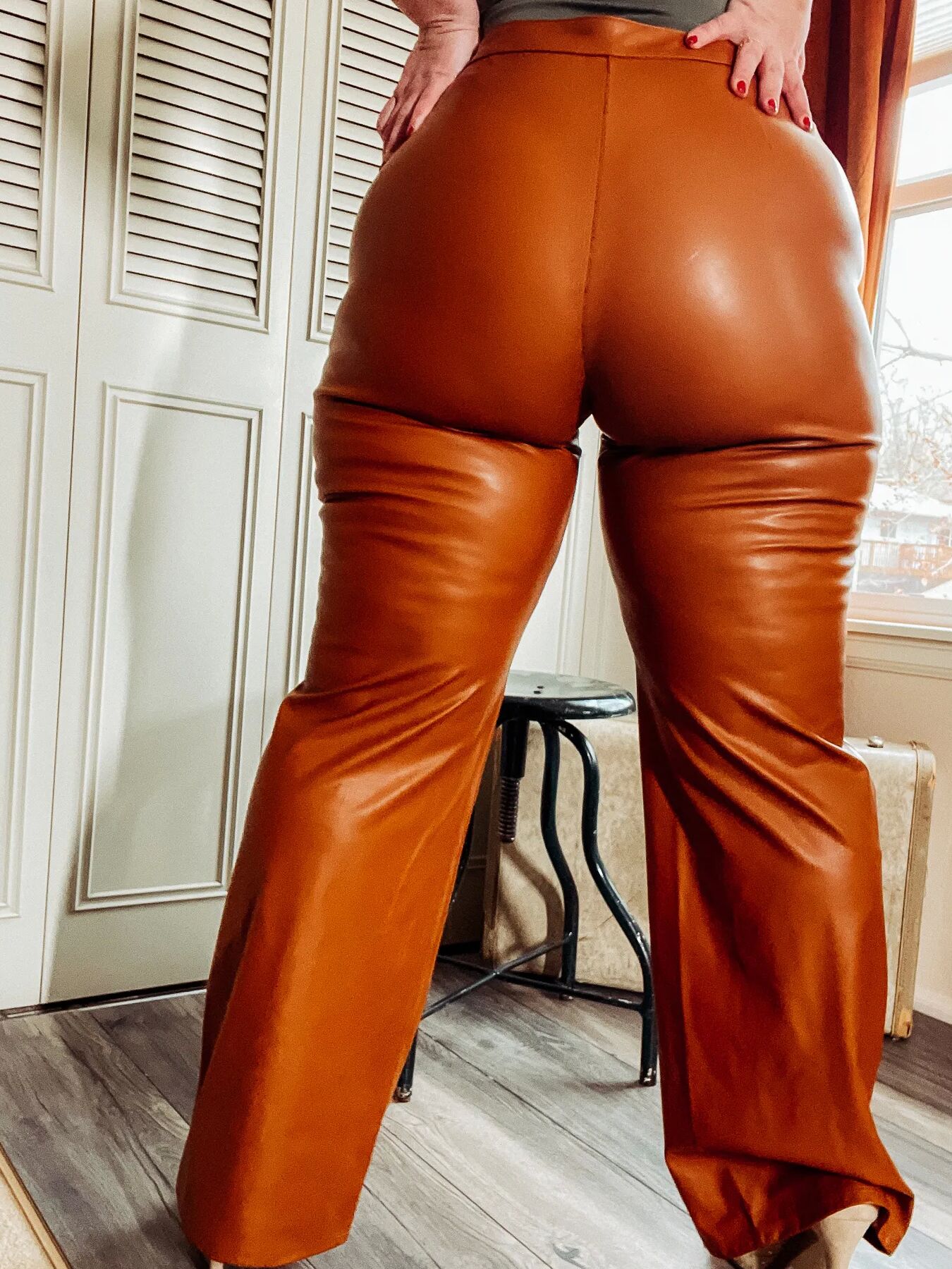 BBW in tight leather pants leans over and shows off her ass