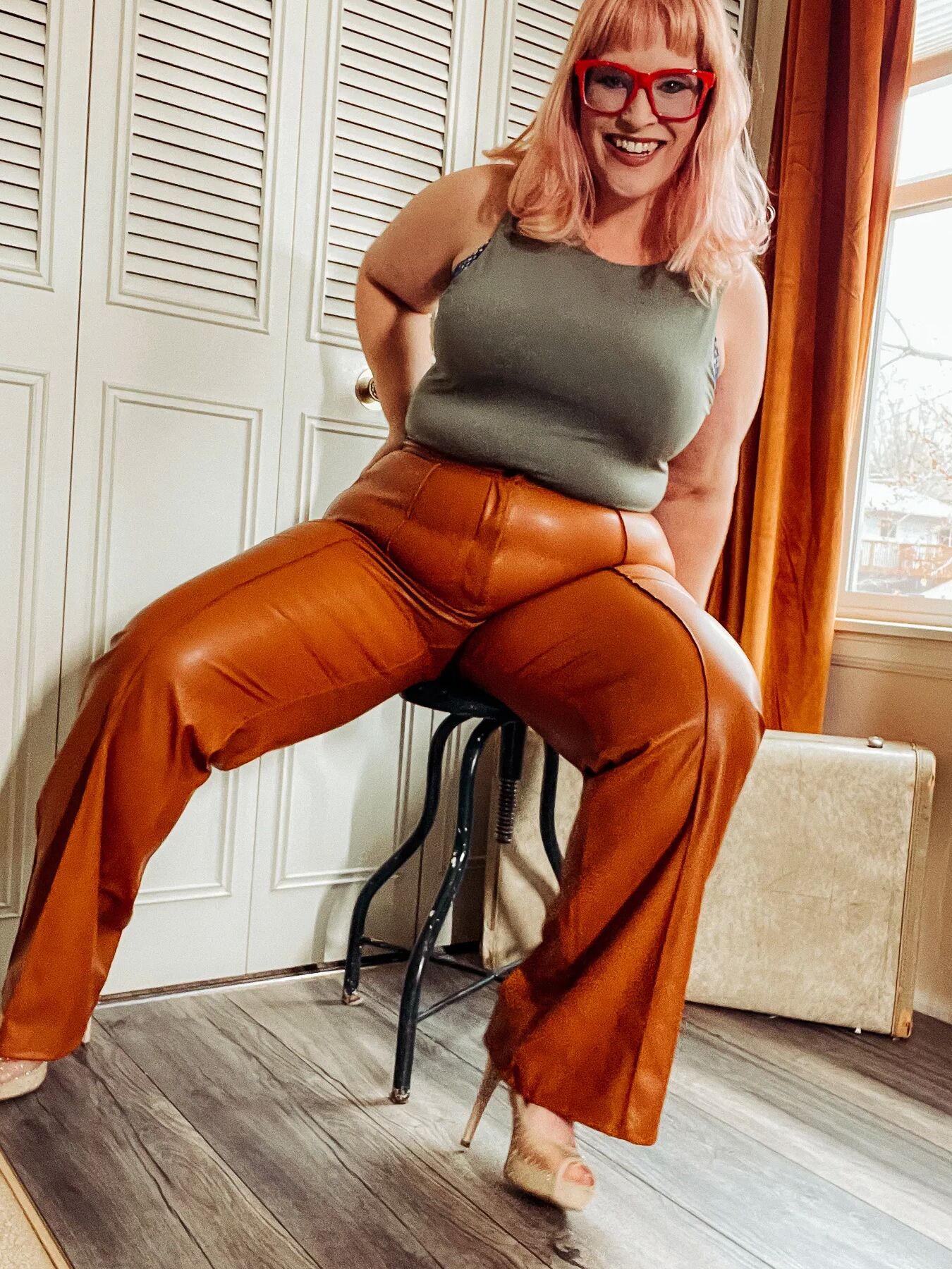 BBW in tight leather pants leans over and shows off her ass