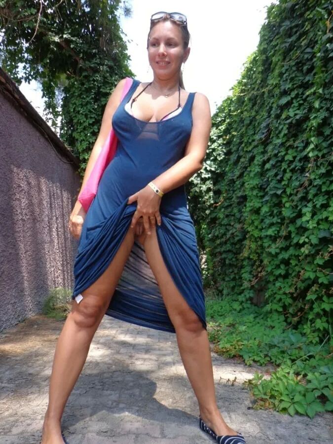 Blonde Milf Lifting Her Dress To Expose Shaved Pussy