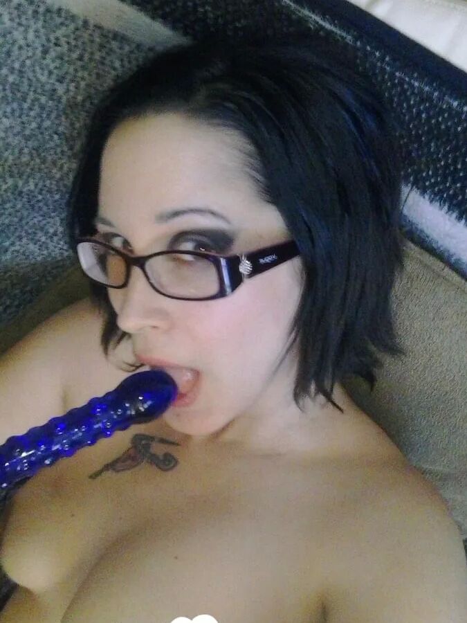 Cutie with glasses sucks on a blue dildo