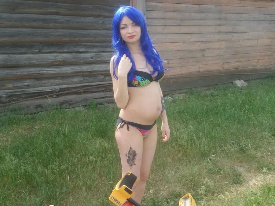 Blue-haired beauty showing her bust while gardening