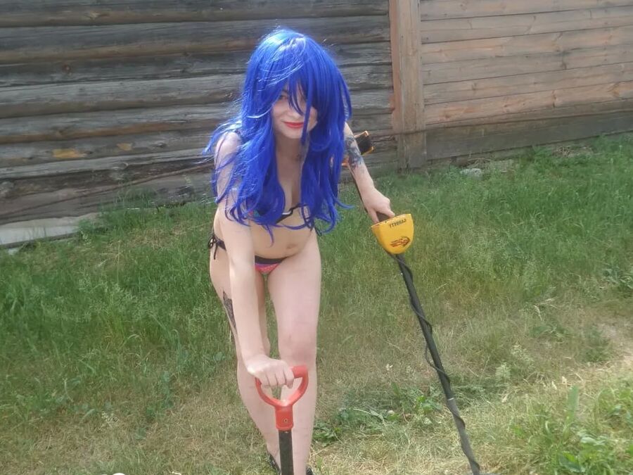 Blue-haired beauty showing her bust while gardening