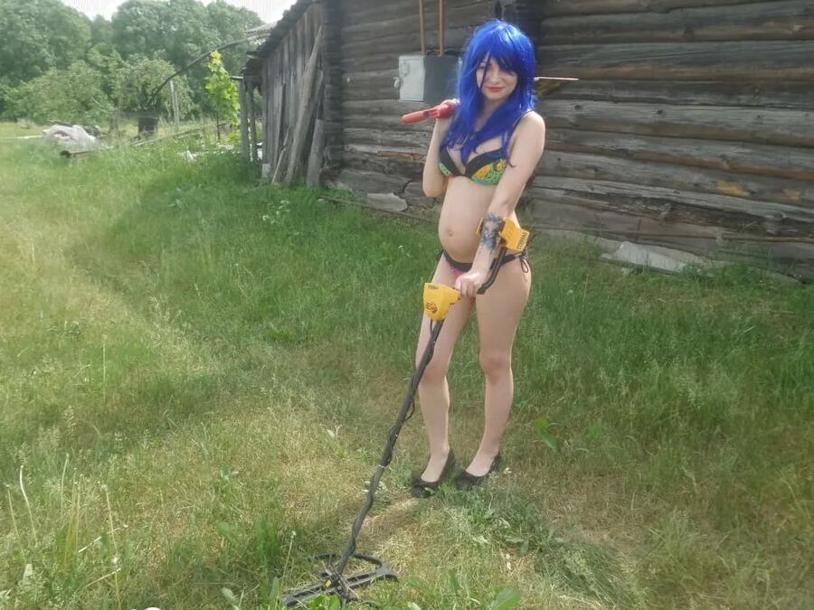 Blue-haired beauty showing her bust while gardening