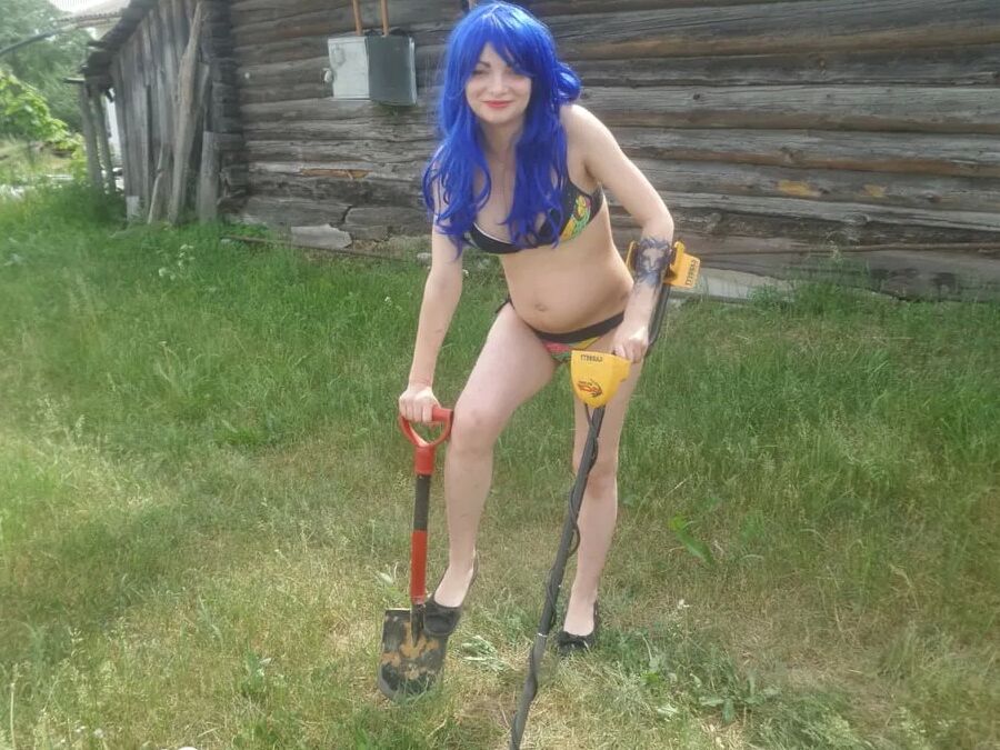 Blue-haired beauty showing her bust while gardening