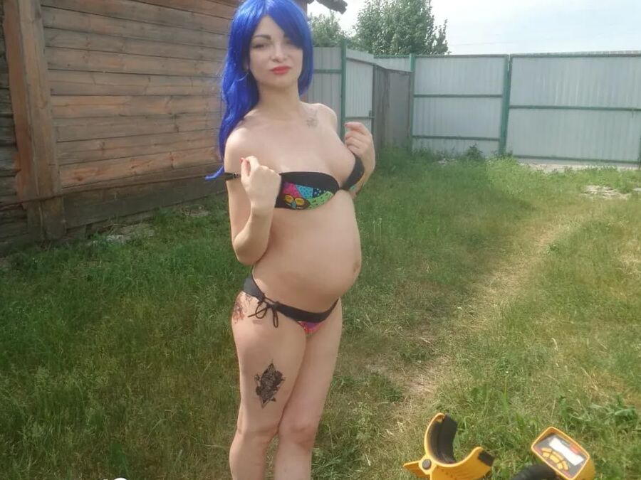 Blue-haired beauty showing her bust while gardening