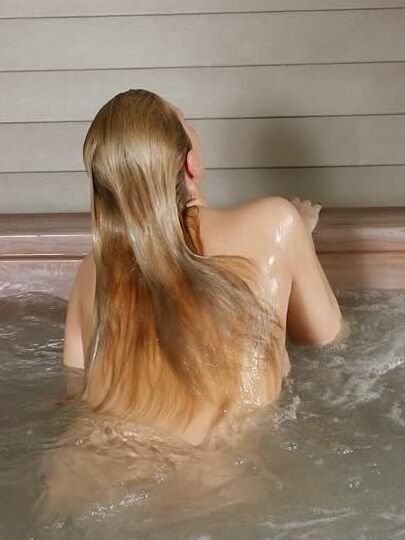 Big breasted young blonde taking a spa bath