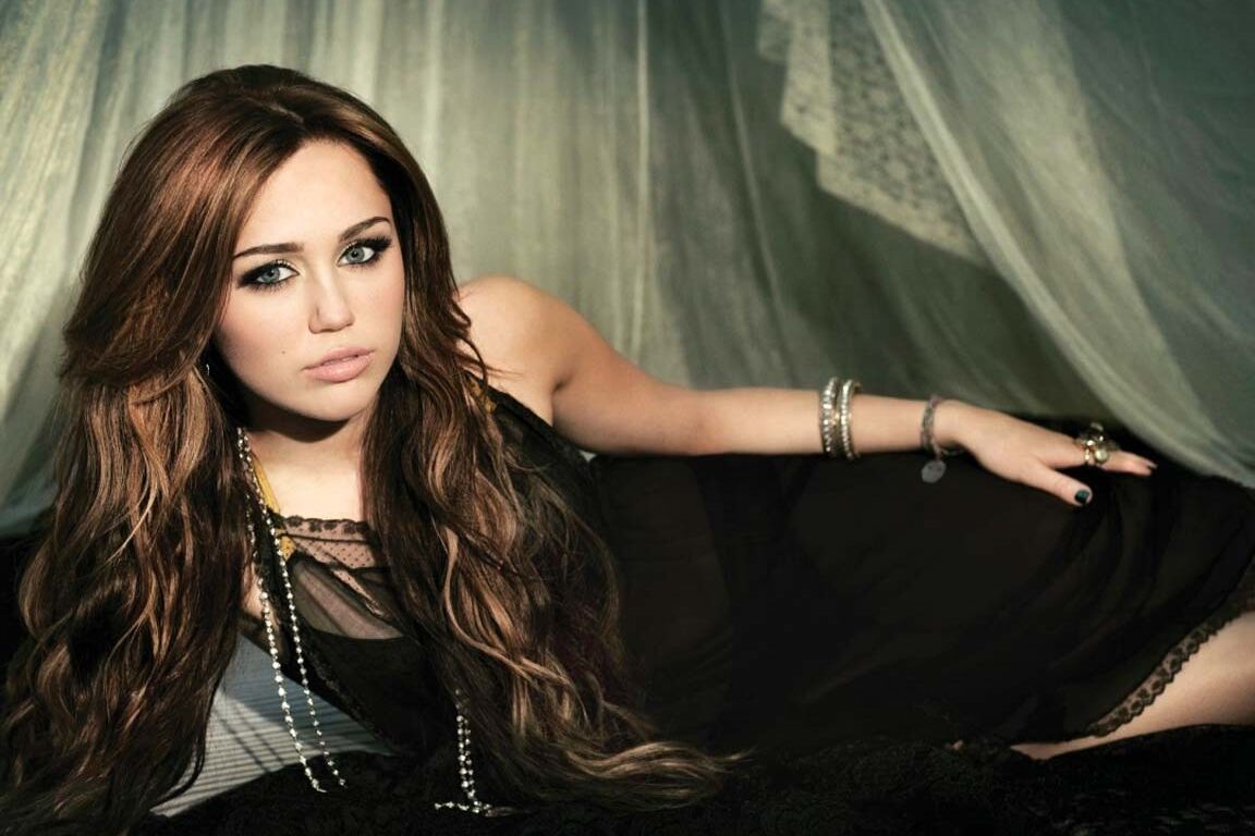 Miley Cyrus showing huge cleavage and great legs in some photoshoot