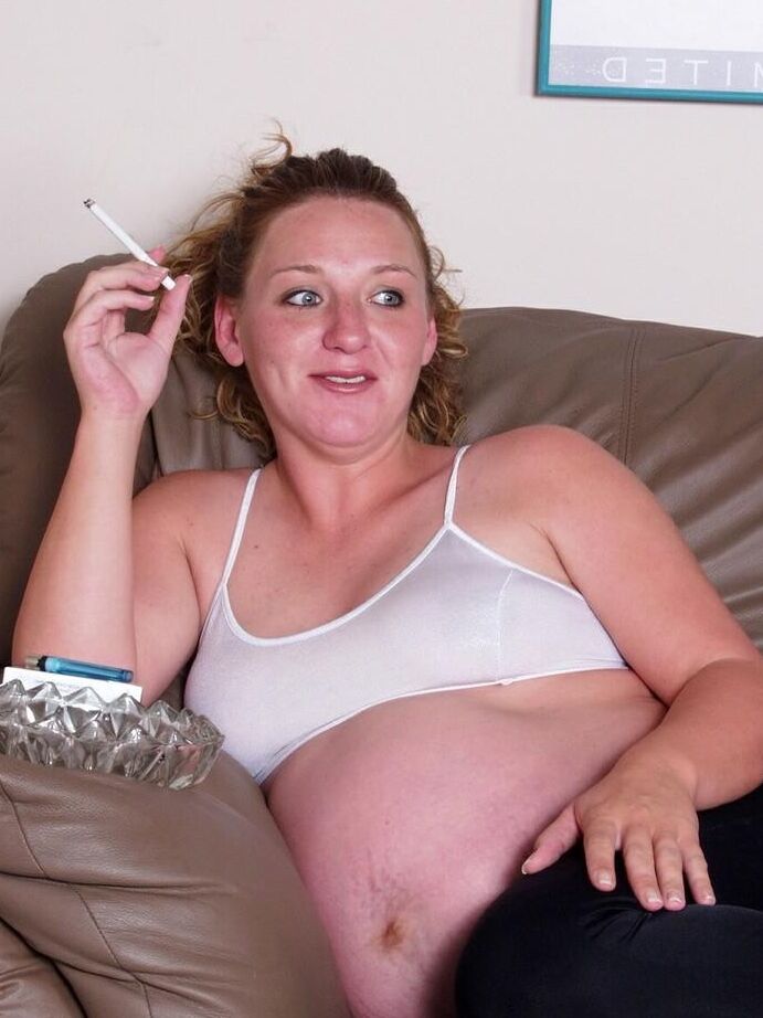 Smoking prego babe on a couch teasing while masturbating