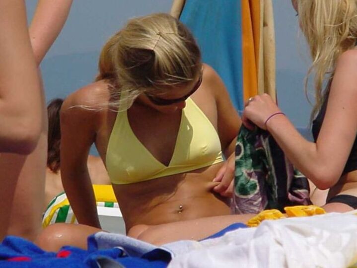 Blonde milf nudist strips down naked at a public beach