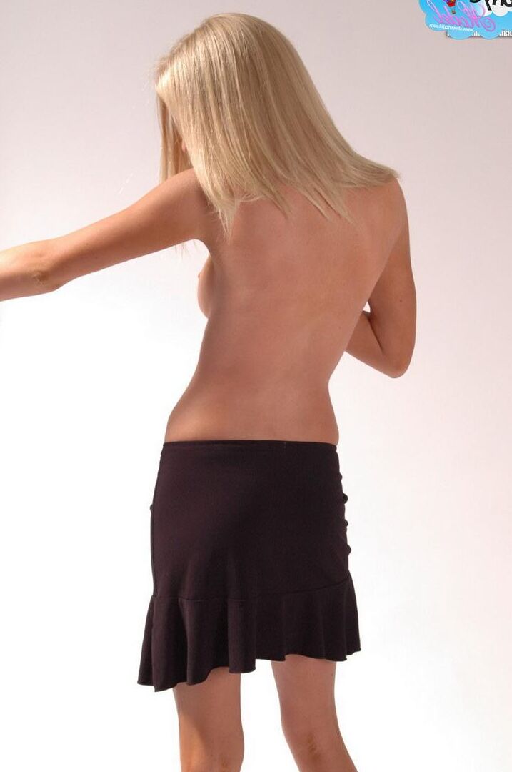 Blonde teen Skye teases as she strips out of her tight corset and skimpy little g-string